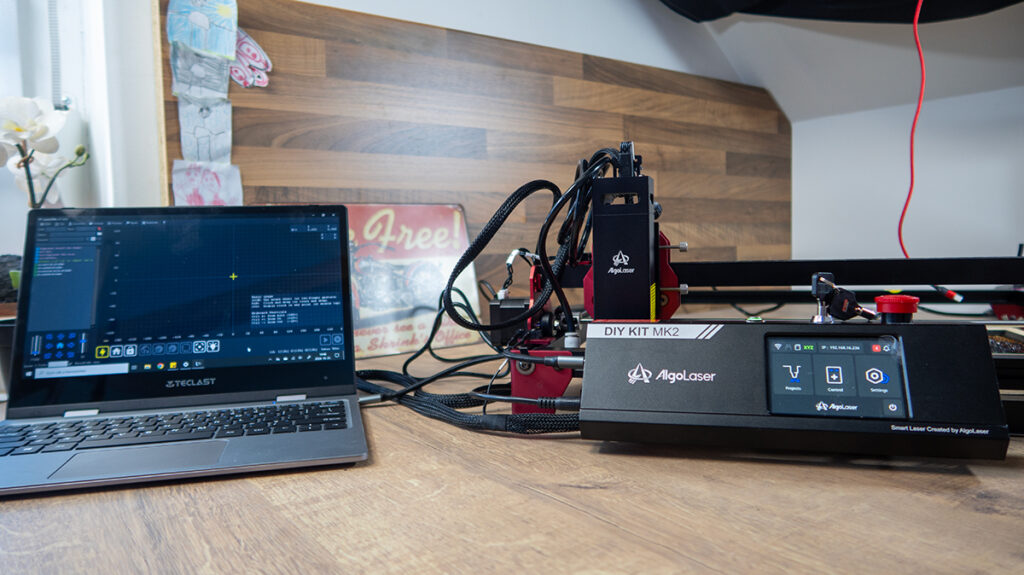 a laptop next to a machine AlgoLaser DIY KIT MK2