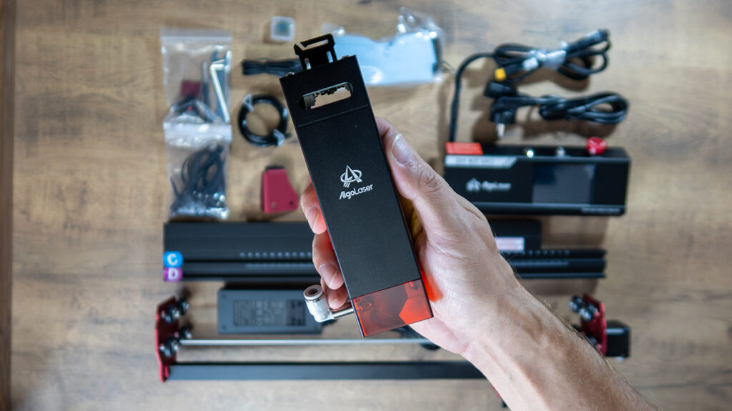 a person holding a black rectangular object with a red cover AlgoLaser DIY KIT MK2