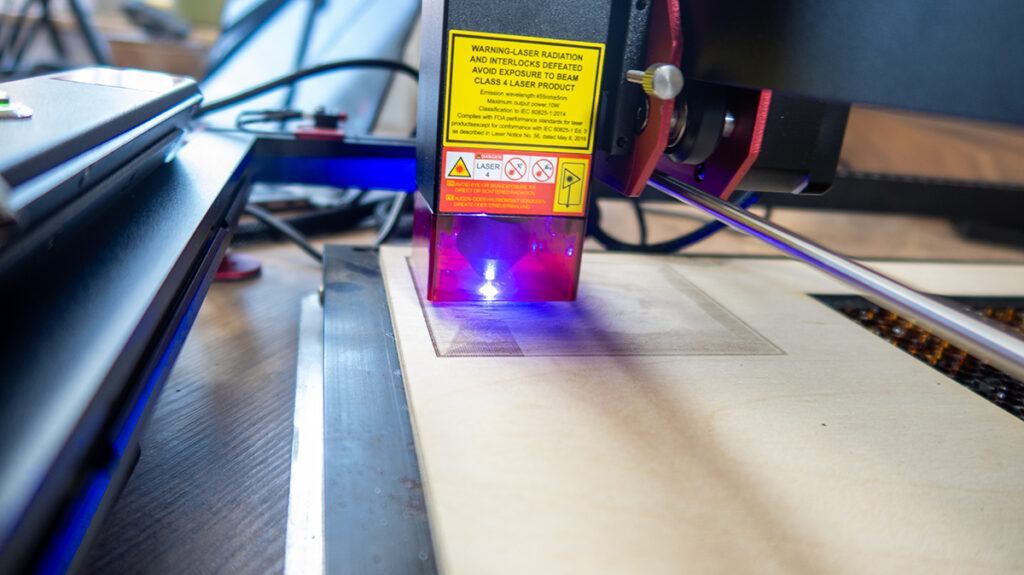 a laser engraving machine with a yellow label AlgoLaser DIY KIT MK2